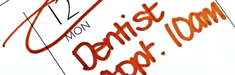 closeup of a calendar square with a reminder in red writing about a scheduled dentist appointment